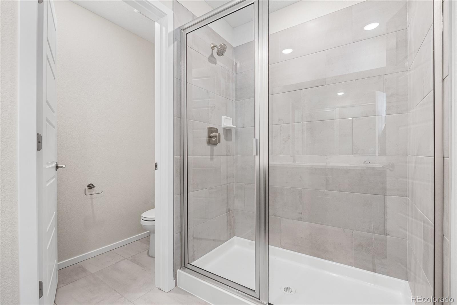 13181 Front Porch Lane Firestone, CO 80504 - Photo 27 of 34 a bathroom with a shower and a glass door
