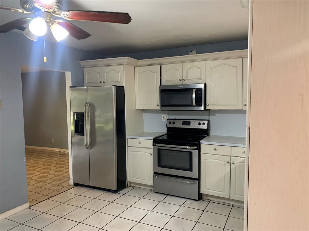 1080 Southwest 14th Street Deerfield Beach, FL 33441 - Photo 4 of 7 a kitchen with stainless steel appliances granite countertop a refrigerator a stove a microwave oven with white cabinets