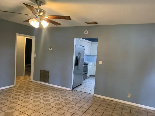 a view of a hallway with a chandelier fan and fire place