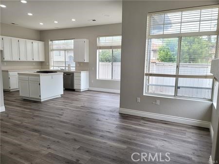 45617 Corte Montril Temecula, CA 92592 - Photo 28 of 50 a large kitchen with kitchen island granite countertop a stove a sink a refrigerator and white cabinets with wooden floor