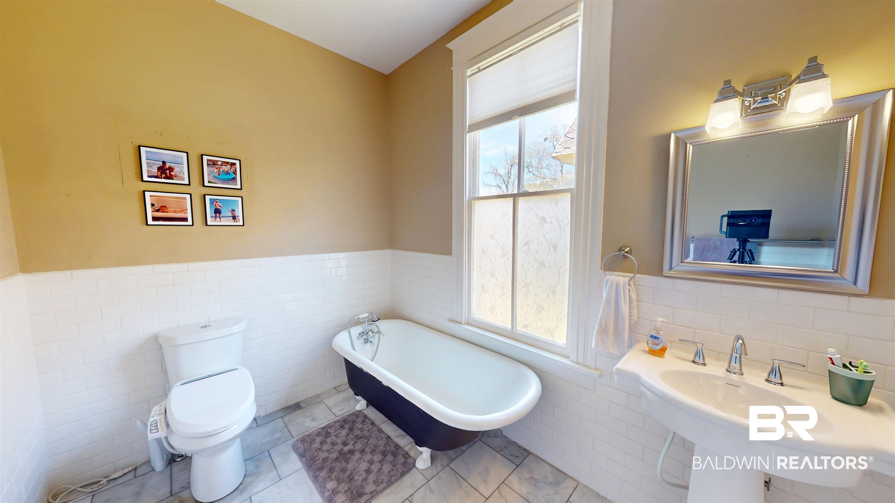 1154 New St Francis Street Mobile, AL 36604 - Photo 15 of 37 Bathroom featuring a wealth of natural light, a freestanding tub, toilet, and a wainscoted wall