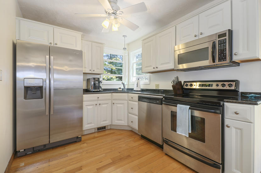 2 Samoset Road Mashpee, MA 02649 - Photo 11 of 41 a kitchen with stainless steel appliances granite countertop a refrigerator a stove a microwave oven with white cabinets and wooden floor