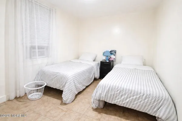 a spacious bedroom with two beds and a potted plant