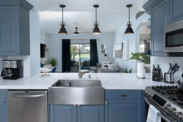 a kitchen with stainless steel appliances a sink a stove and a wooden floor