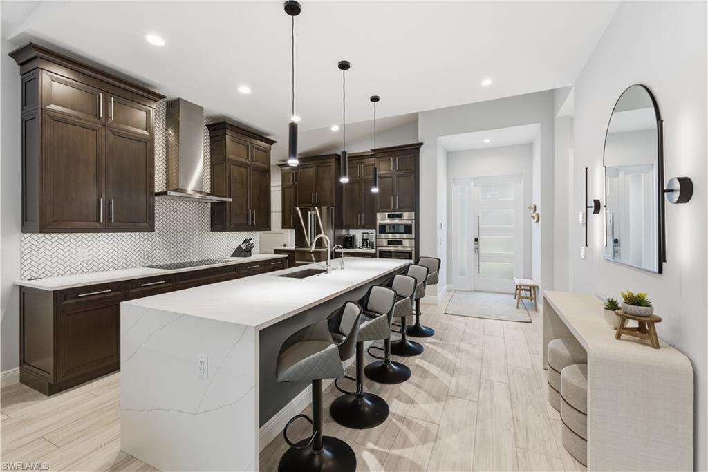 711 91st Avenue North Naples, FL 34108 - Photo 7 of 27 a kitchen with a sink stainless steel appliances and cabinets