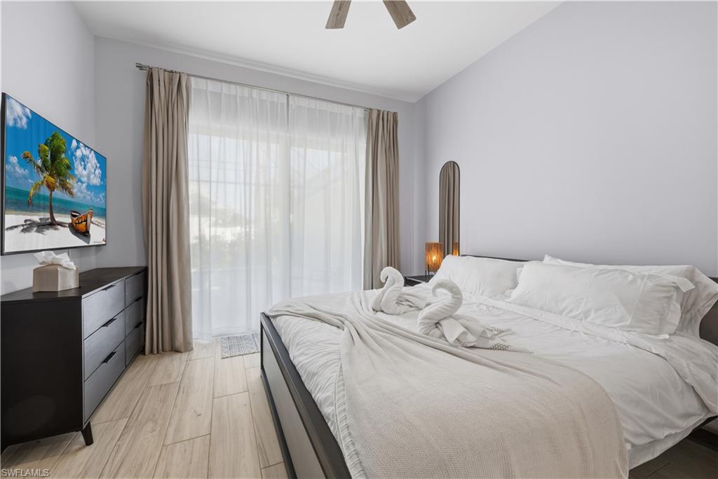 711 91st Avenue North Naples, FL 34108 - Photo 9 of 27 a bedroom with a bed and a flat tv screen on dresser