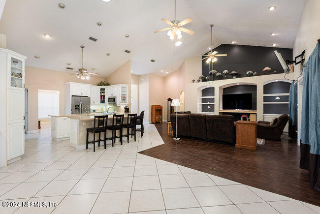 8092 Collins Road Jacksonville, FL 32244 - Photo 11 of 42 a living room with furniture a flat screen tv and kitchen view