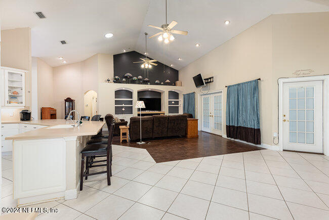 8092 Collins Road Jacksonville, FL 32244 - Photo 12 of 42 a living room with furniture a fireplace and kitchen view