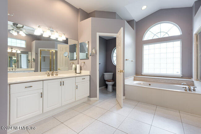 8092 Collins Road Jacksonville, FL 32244 - Photo 19 of 42 a spacious en suite bathroom with a double vanity sink a large mirror and a bathtub with shower