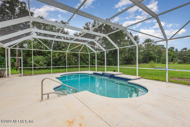8092 Collins Road Jacksonville, FL 32244 - Photo 32 of 42 a view of a swimming pool with a yard in front of it