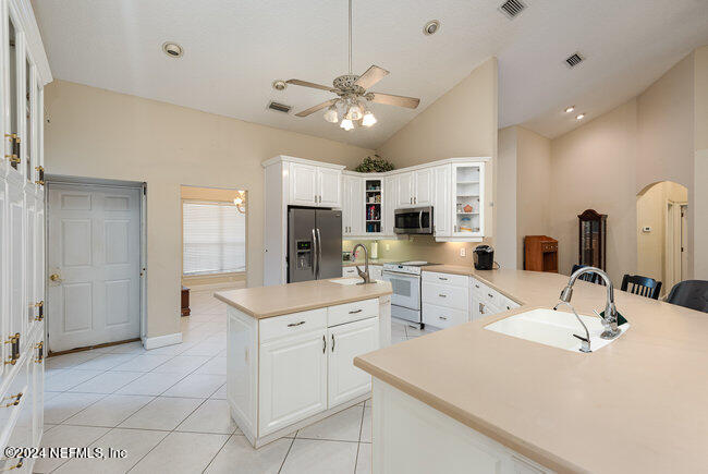 8092 Collins Road Jacksonville, FL 32244 - Photo 7 of 42 a kitchen with a sink a center island and stainless steel appliances