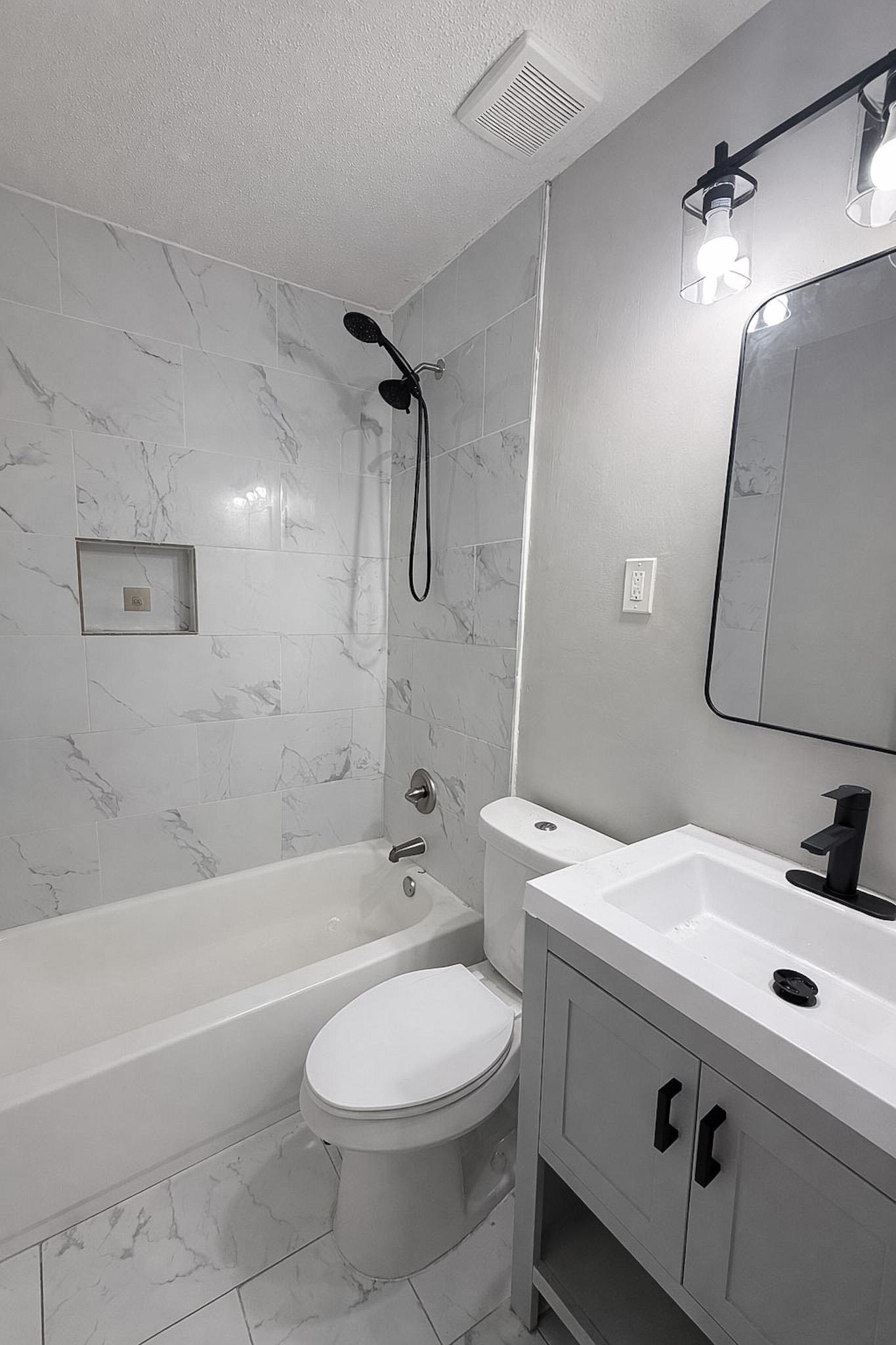 4174 Hobson Road Memphis, TN 38128 - Photo 23 of 24 Full bathroom featuring vanity, light marble finish floors, shower / bathtub combination, and a textured ceiling