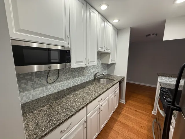 a kitchen with stainless steel appliances granite countertop a sink stove and microwave
