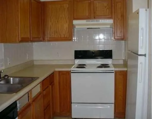 a stove top oven sitting inside of a kitchen