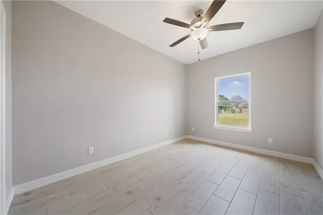 an empty room with a window and a fan