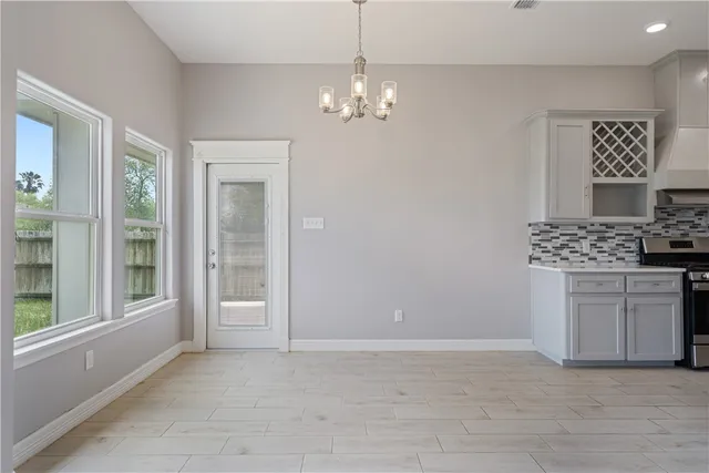 a view of kitchen with granite countertop cabinets and window
