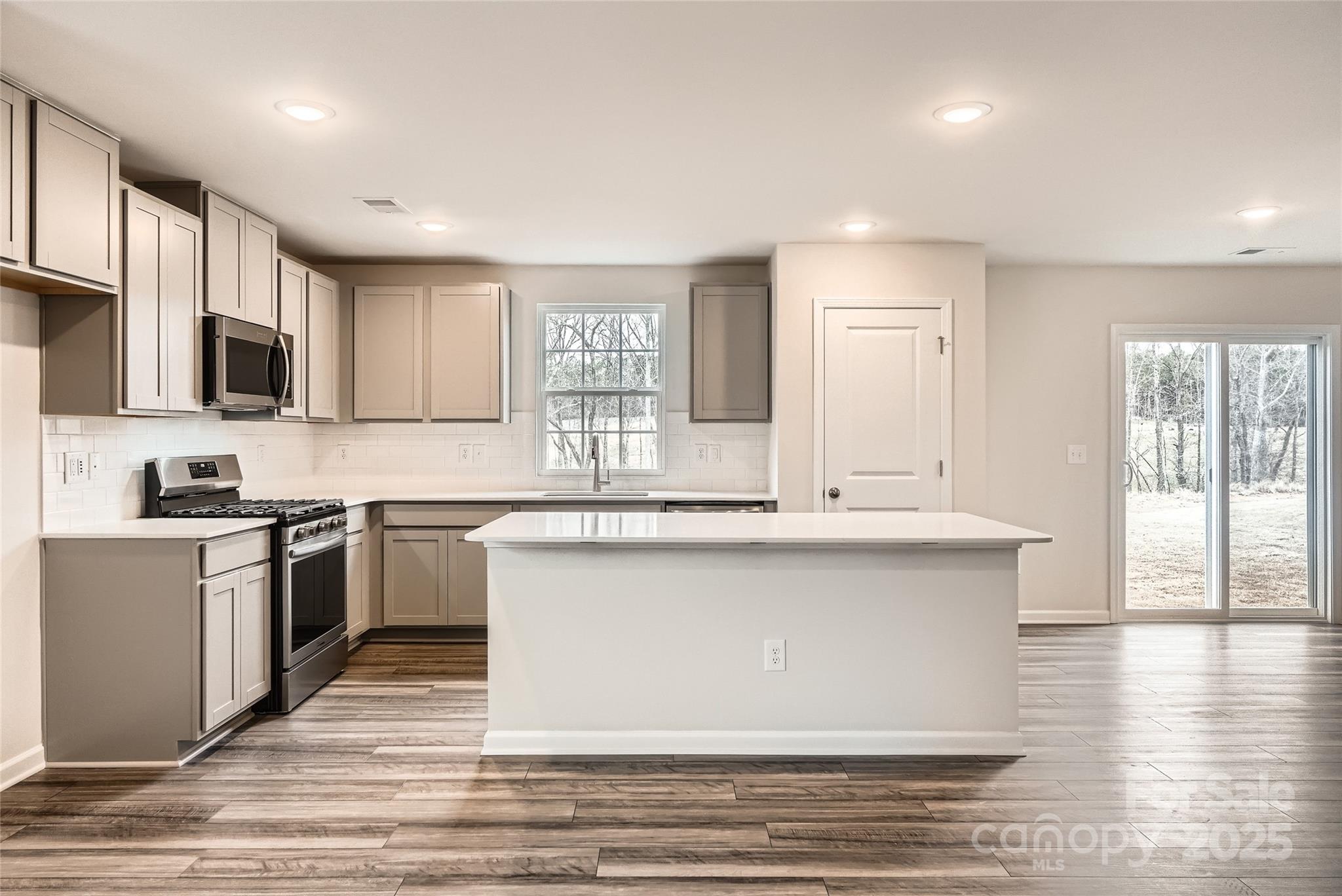 1187 Blackburn Circle Edgemoor, SC 29712 - Photo 6 of 14 a kitchen with stainless steel appliances granite countertop a sink a stove a microwave a sink and cabinets