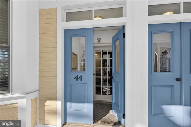 a view of a hallway with wooden floor and a living room
