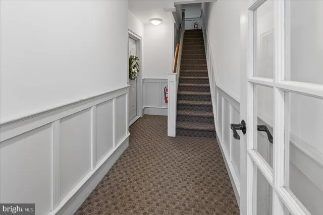 a view of staircase with lots of frames on wall and wooden floor