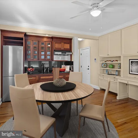 a living room with stainless steel appliances furniture a rug and a kitchen view