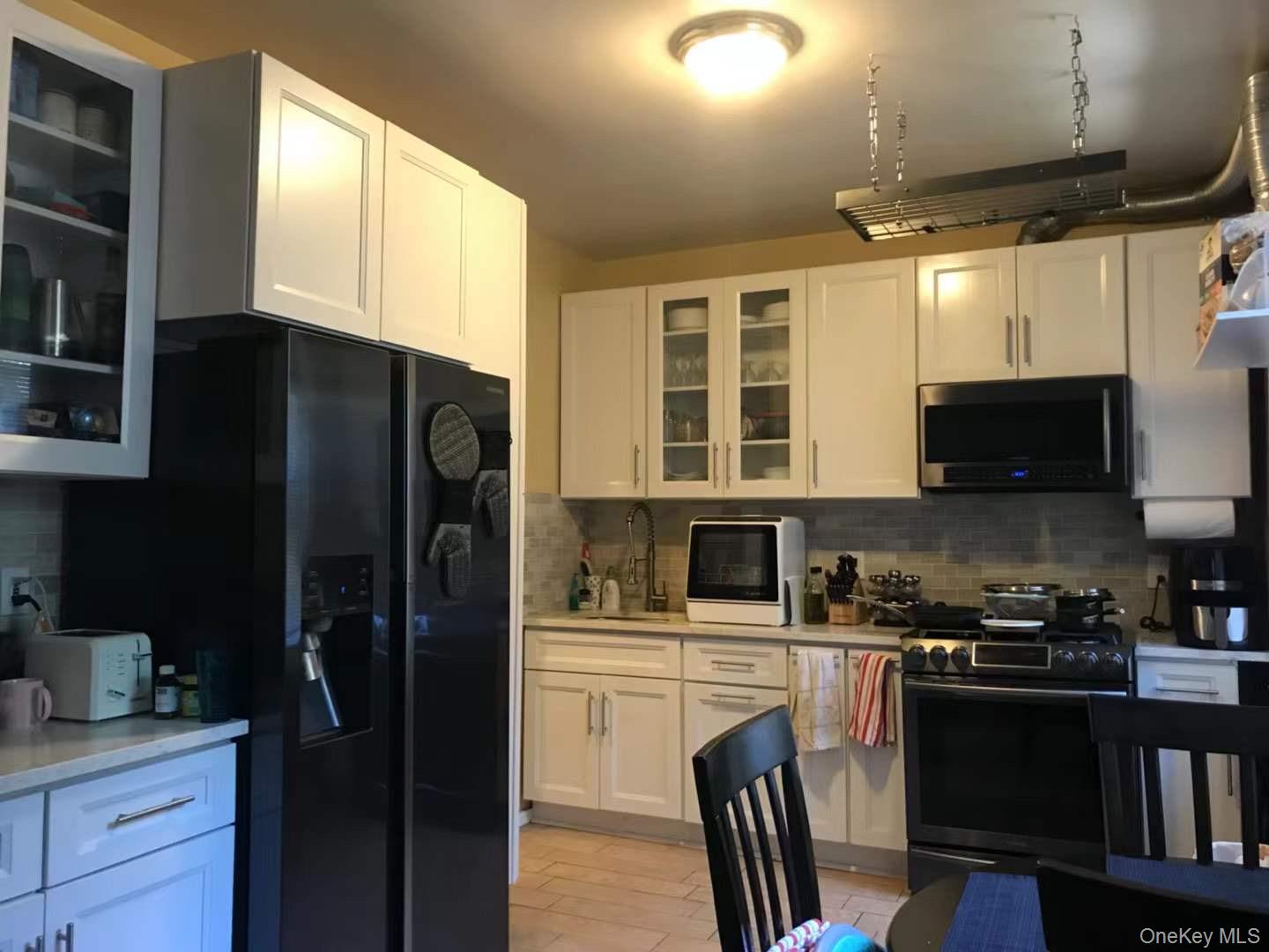 61-40 Saunders Street, Unit C5 Queens, NY 11374 - Photo 3 of 7 a kitchen with stainless steel appliances granite countertop a refrigerator stove top oven a sink and dishwasher