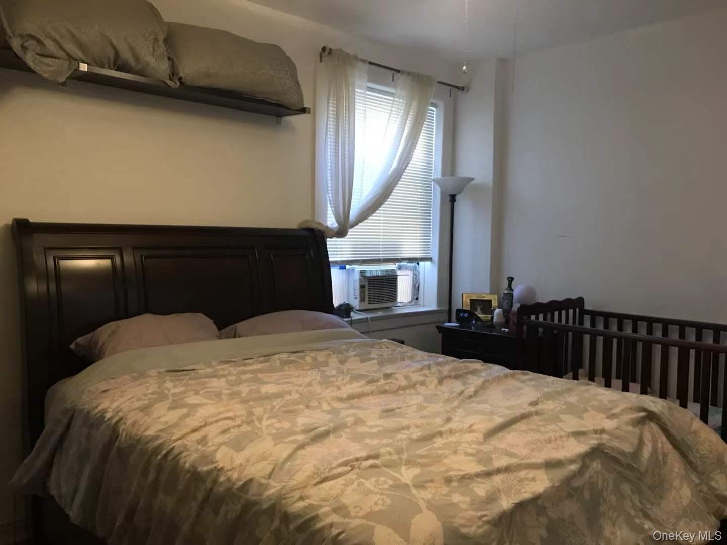 61-40 Saunders Street, Unit C5 Queens, NY 11374 - Photo 6 of 7 a bedroom with a bed and a mirror