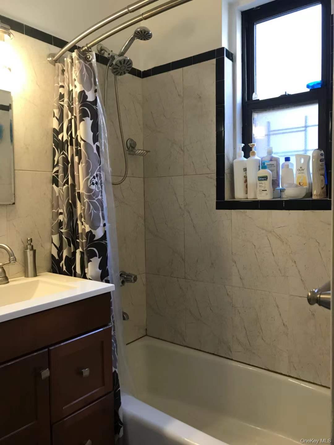 61-40 Saunders Street, Unit C5 Queens, NY 11374 - Photo 7 of 7 a bathroom with a sink a mirror and a shower