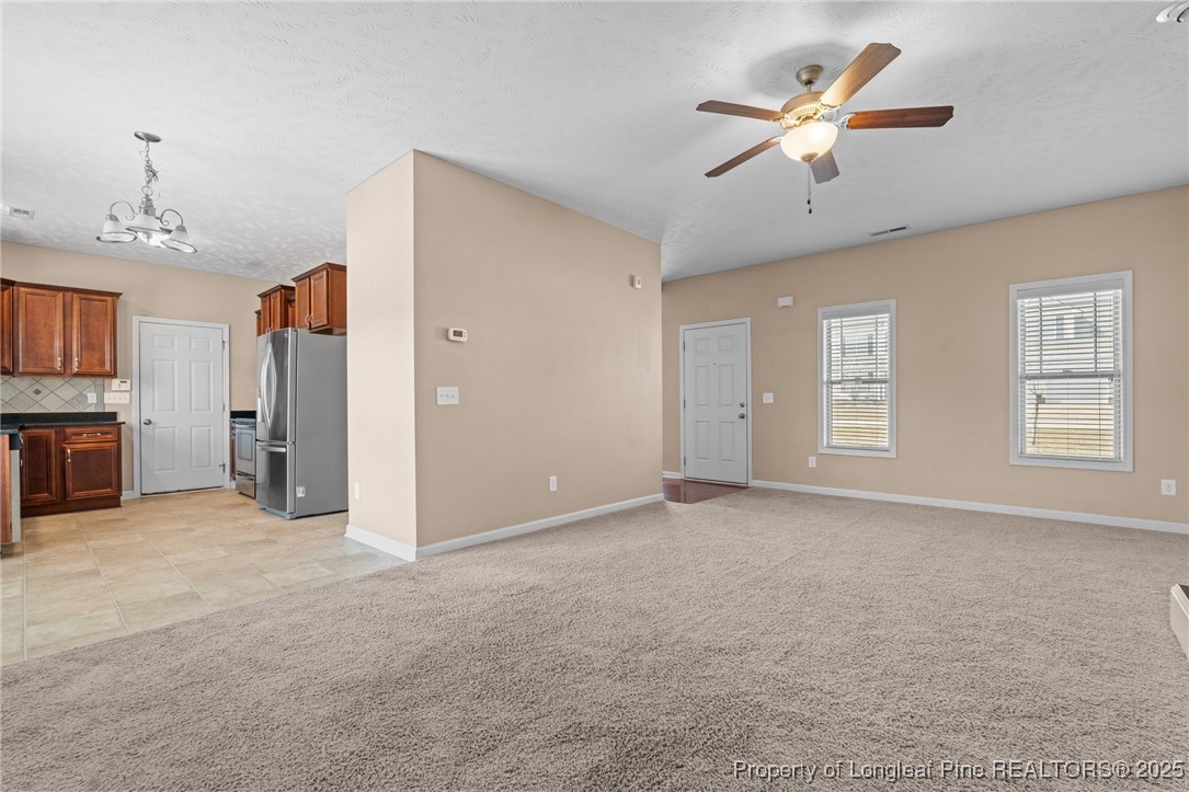 43 Battery Way Bunnlevel, NC 28323 - Photo 19 of 50 an empty room with chandelier fan and windows