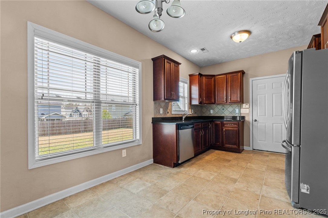 43 Battery Way Bunnlevel, NC 28323 - Photo 21 of 50 a kitchen with granite countertop a refrigerator and a stove top oven