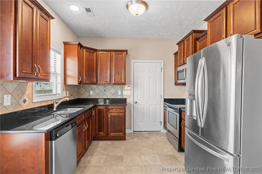 43 Battery Way Bunnlevel, NC 28323 - Photo 25 of 50 a kitchen with granite countertop a refrigerator and a sink