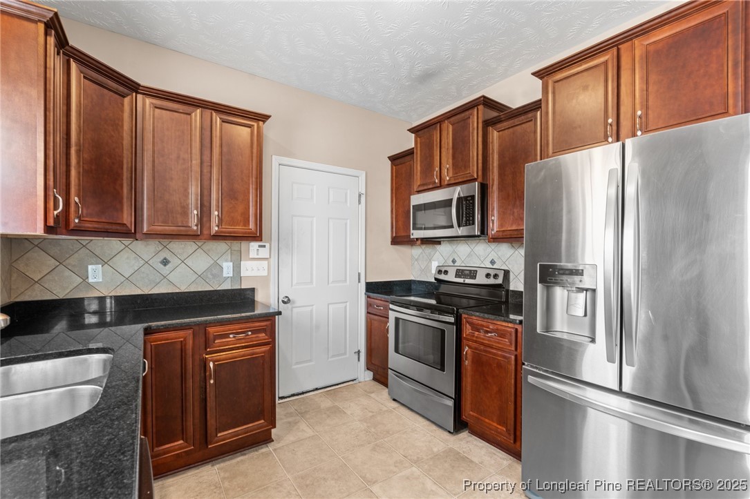 43 Battery Way Bunnlevel, NC 28323 - Photo 26 of 50 a kitchen with stainless steel appliances granite countertop a refrigerator stove and sink