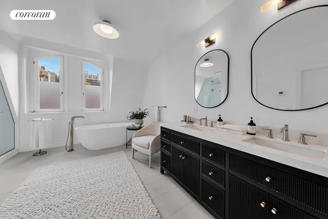 a spacious bathroom with a double vanity sink double mirror and bathtub
