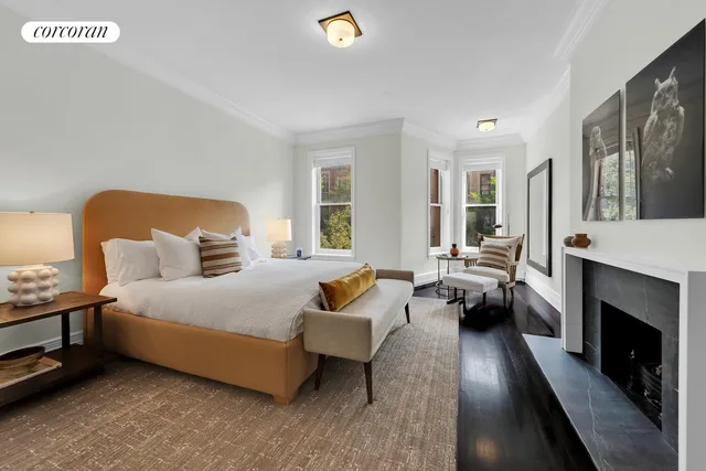 a spacious bedroom with a bed a couch and a fireplace with the outer view