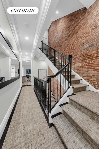 a view of staircase with lots of frames on wall and windows