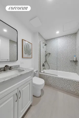 a bathroom with a granite countertop sink a toilet and a mirror