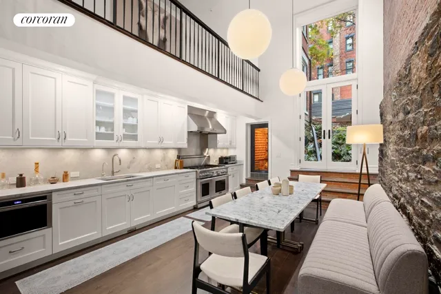 a kitchen with stainless steel appliances granite countertop a dining table chairs sink and cabinets
