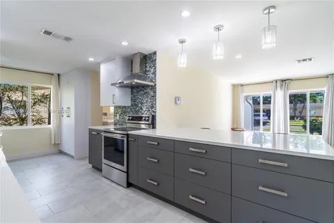 a large kitchen with stainless steel appliances lots of counter space and windows