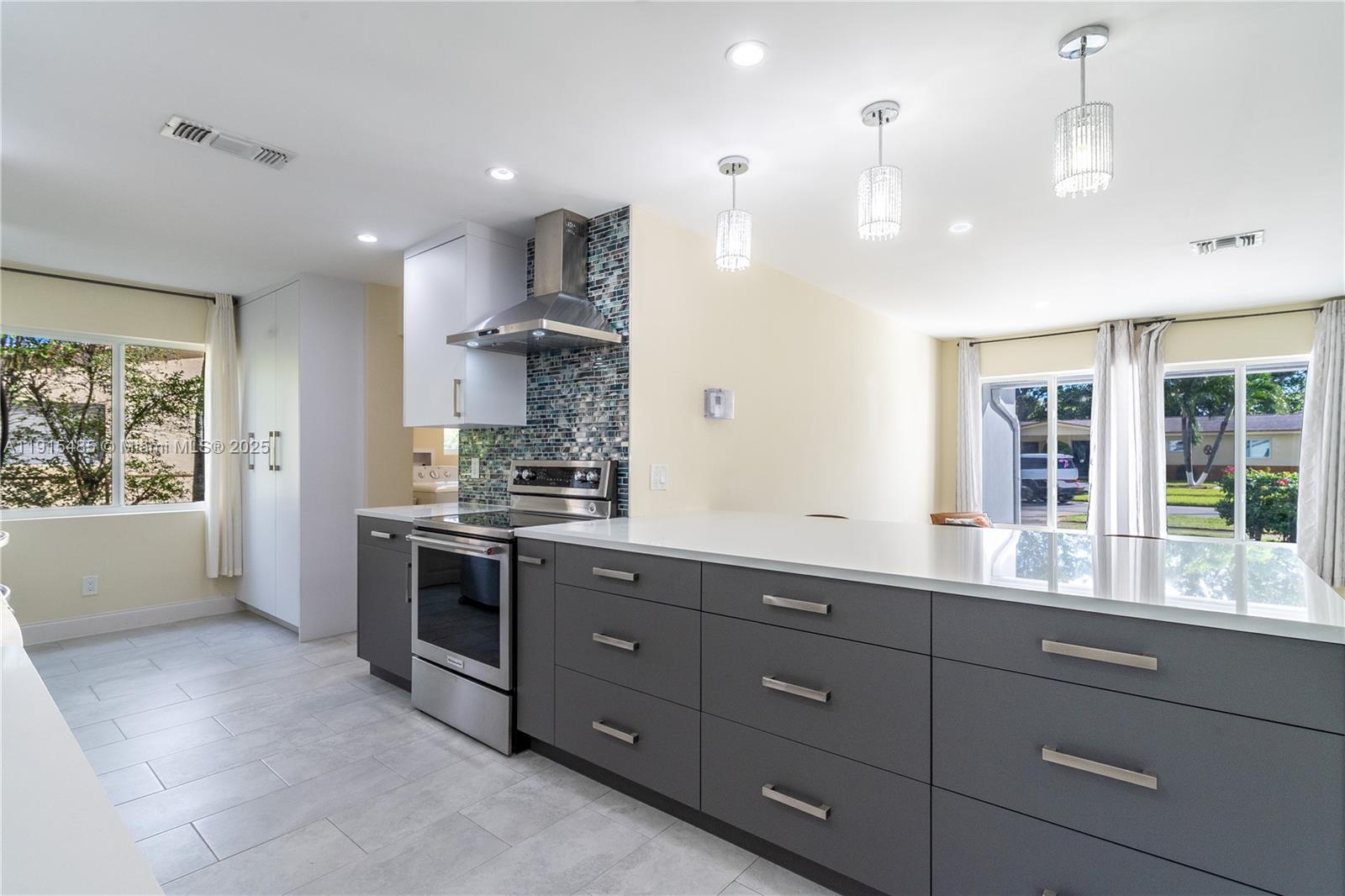 2631 Northwest 47th Avenue Lauderhill, FL 33313 - Photo 3 of 10 a large kitchen with stainless steel appliances lots of counter space and windows