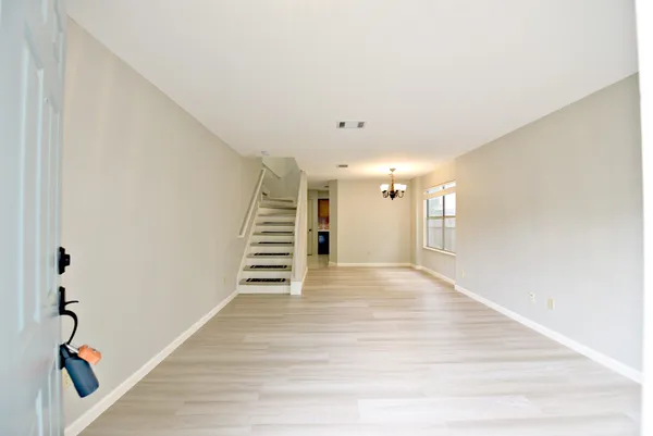 a view of a livingroom with wooden floor and stairs