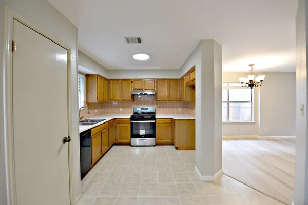 a large kitchen with granite countertop a large counter top stainless steel appliances and cabinets