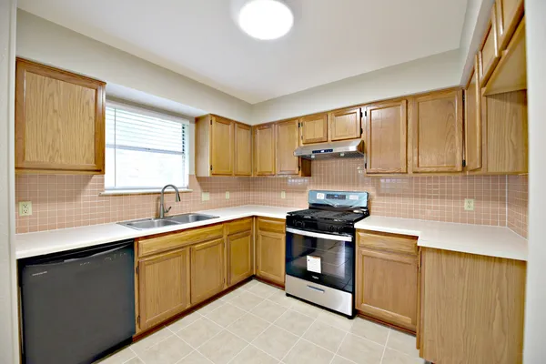 a kitchen with a sink stove and cabinets