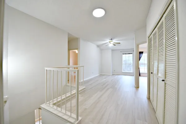 a view of a hallway with wooden floor