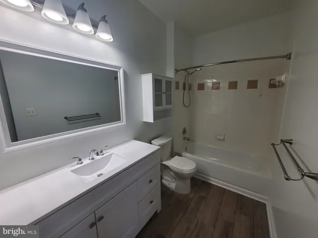 a bathroom with a sink a toilet a mirror and shower