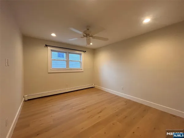 an empty room with a window and a fan