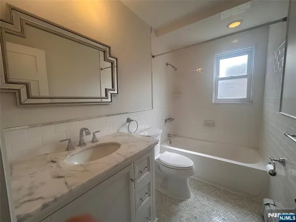 a bathroom with a granite countertop sink a toilet and a bathtub