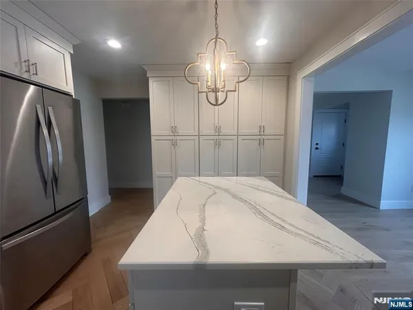 a kitchen with stainless steel appliances a refrigerator and a hard wood floor