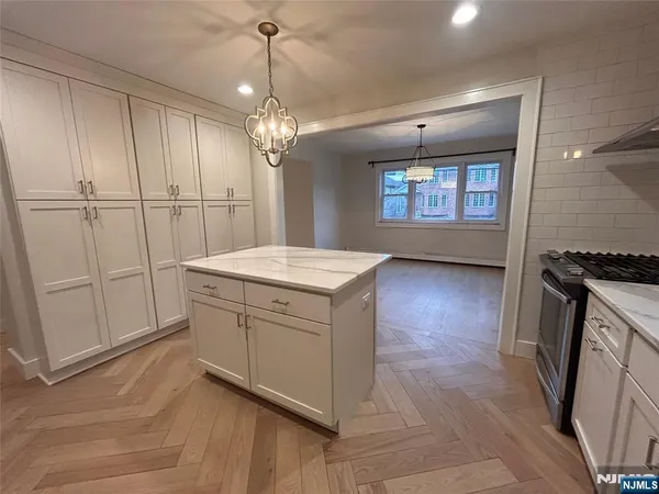 a kitchen with white cabinets and sink