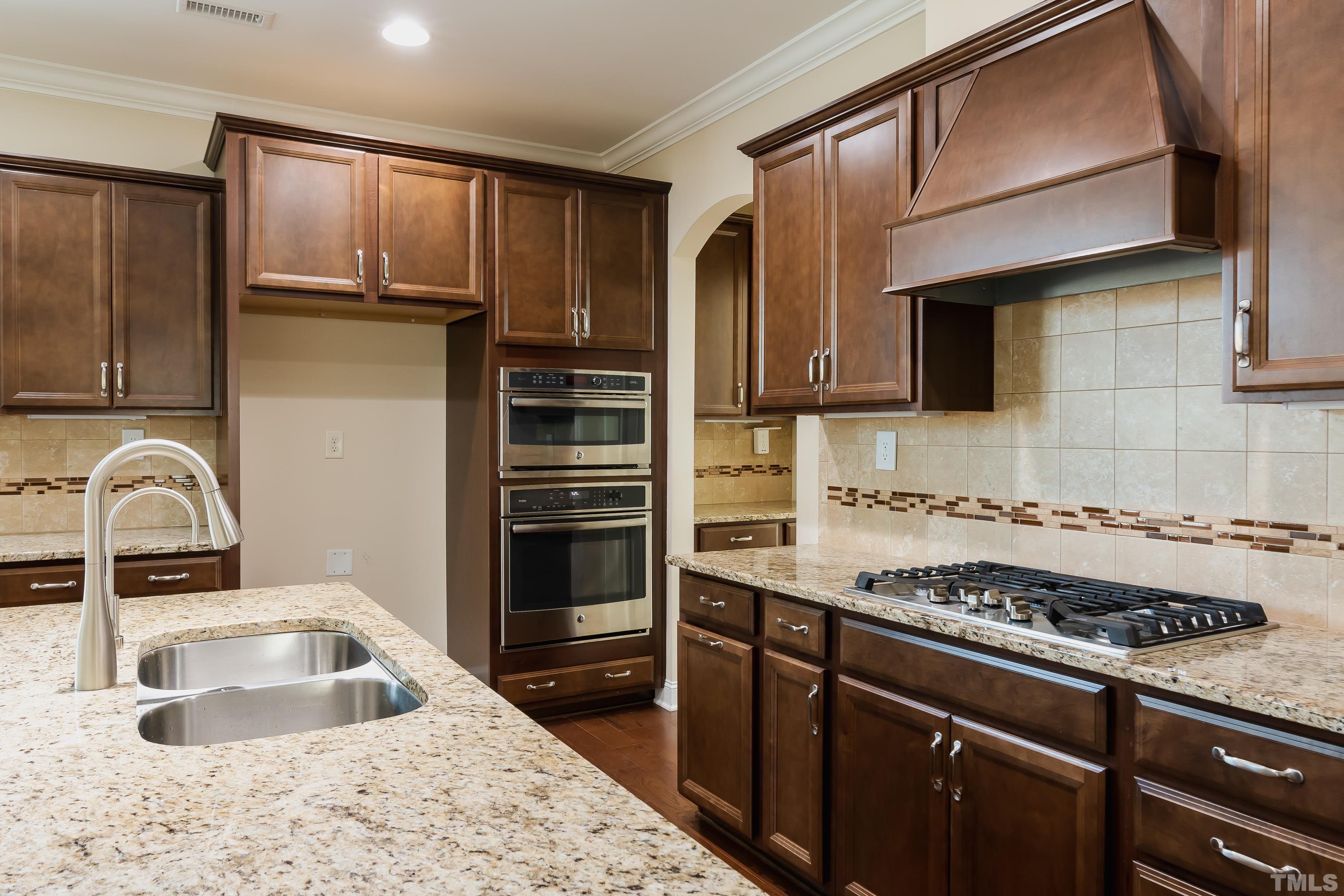 821 Traditions Ridge Drive Wake Forest, NC 27587 - Photo 7 of 14 a kitchen with granite countertop a sink stainless steel appliances and cabinets