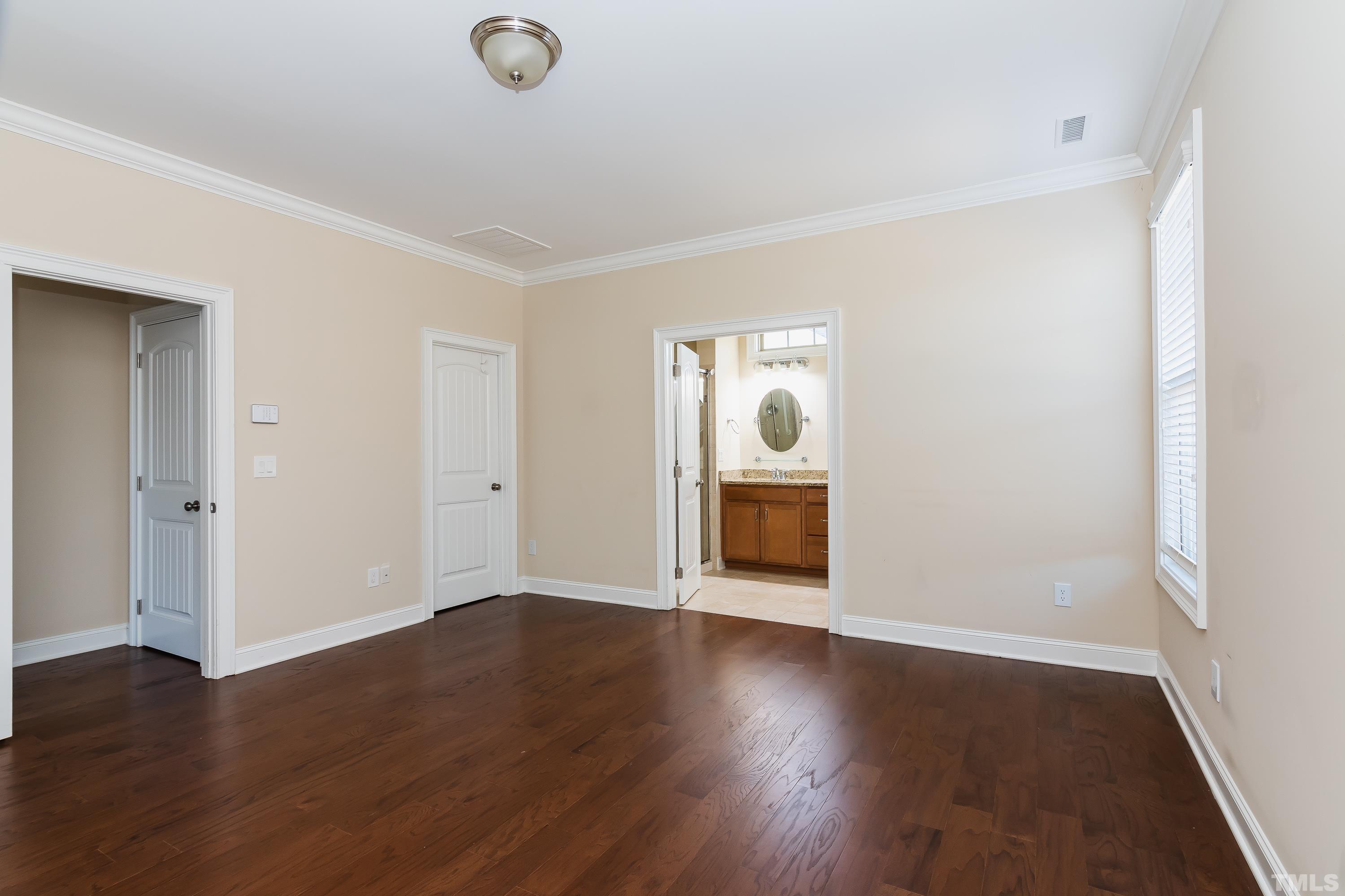821 Traditions Ridge Drive Wake Forest, NC 27587 - Photo 8 of 14 an empty room with wooden floor and windows