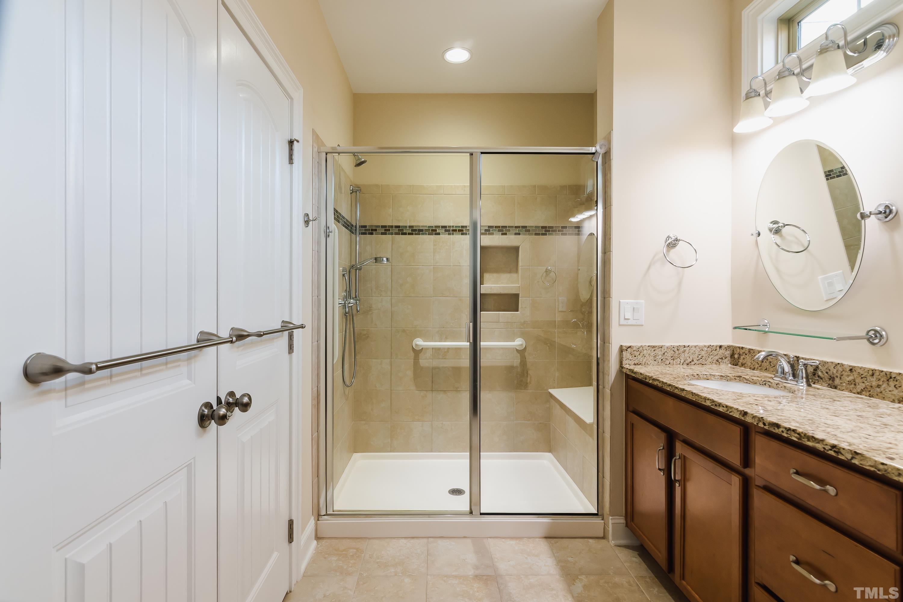 821 Traditions Ridge Drive Wake Forest, NC 27587 - Photo 9 of 14 a bathroom with a granite countertop sink mirror and shower